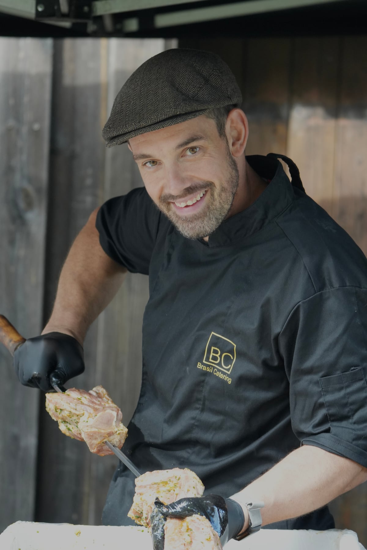Koch von Brasil Catering steckt mariniertes Fleisch auf einen Grillspieß